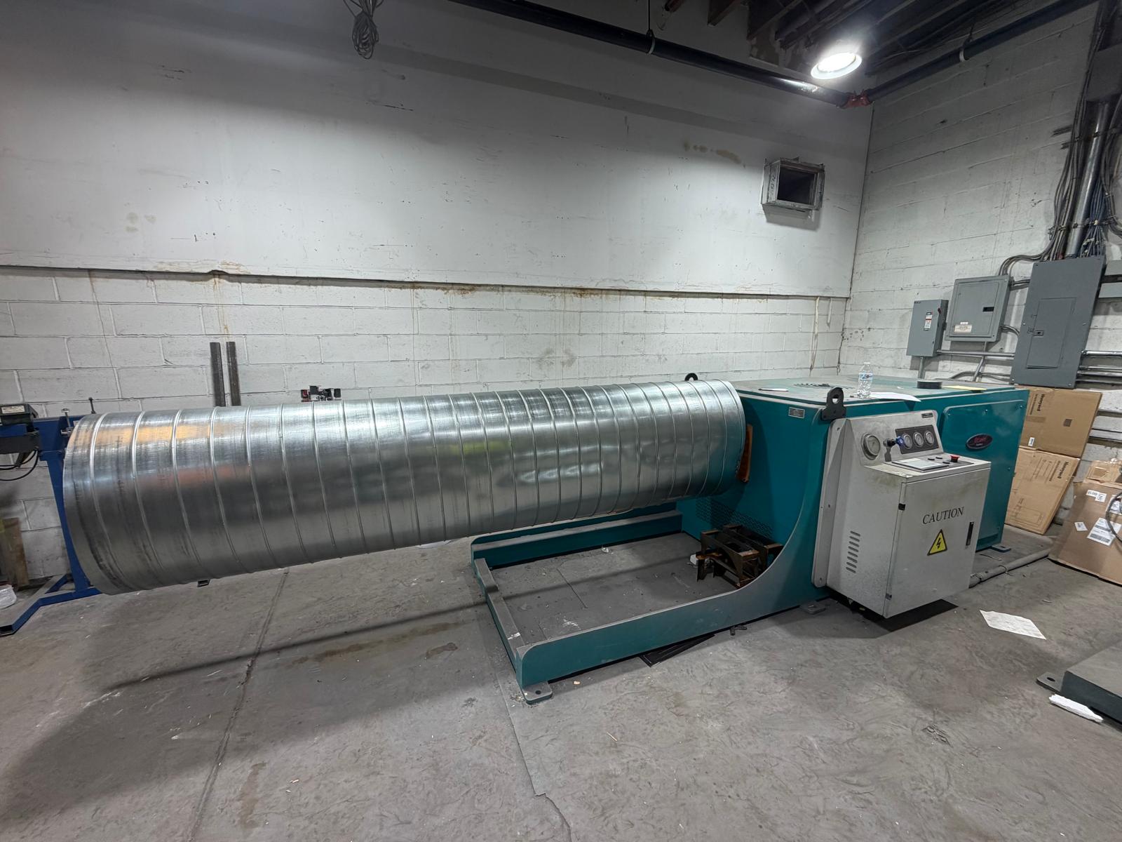 Large oval duct on a fabrication machine in the shop, side view