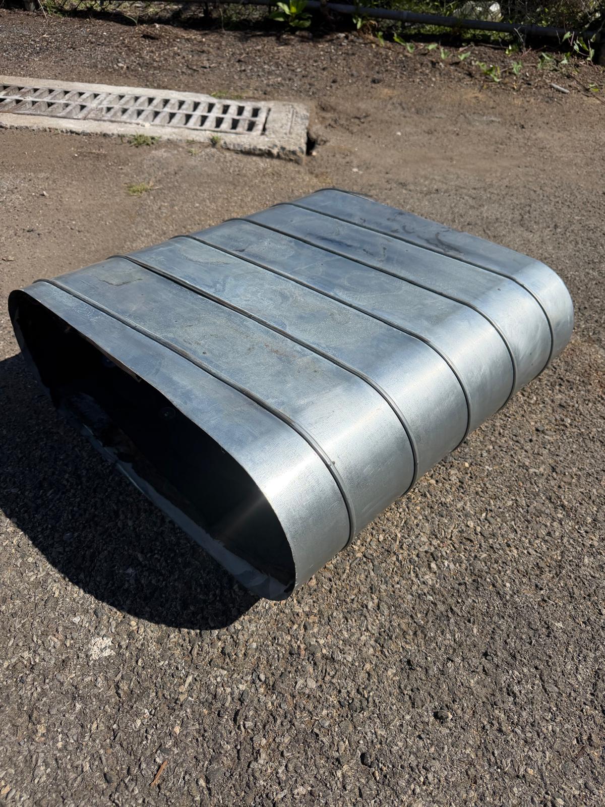 Single oval duct section lying on asphalt