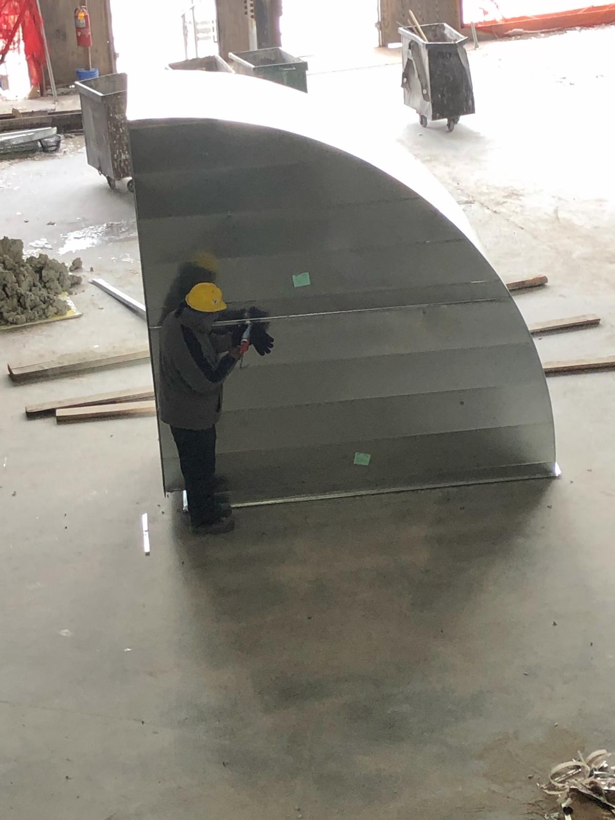 Worker fabricating a large custom rectangular duct component