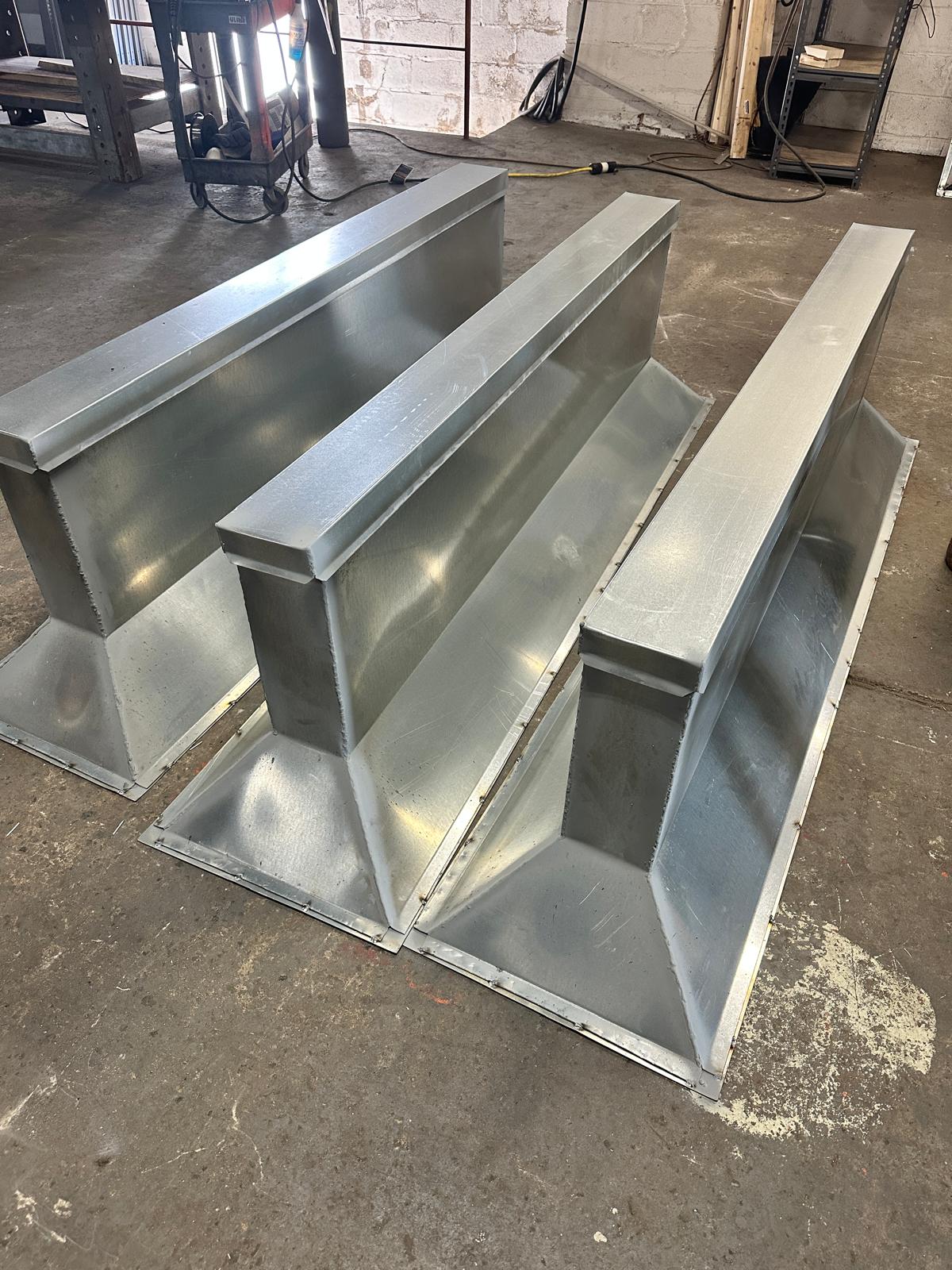 Three finished fabricated sheet metal assemblies in the shop