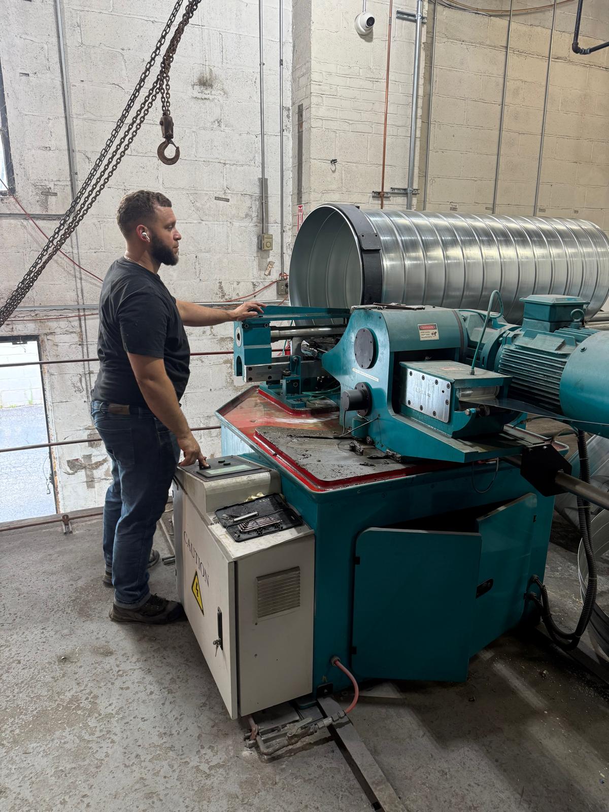 Worker operating sheet metal fabrication equipment