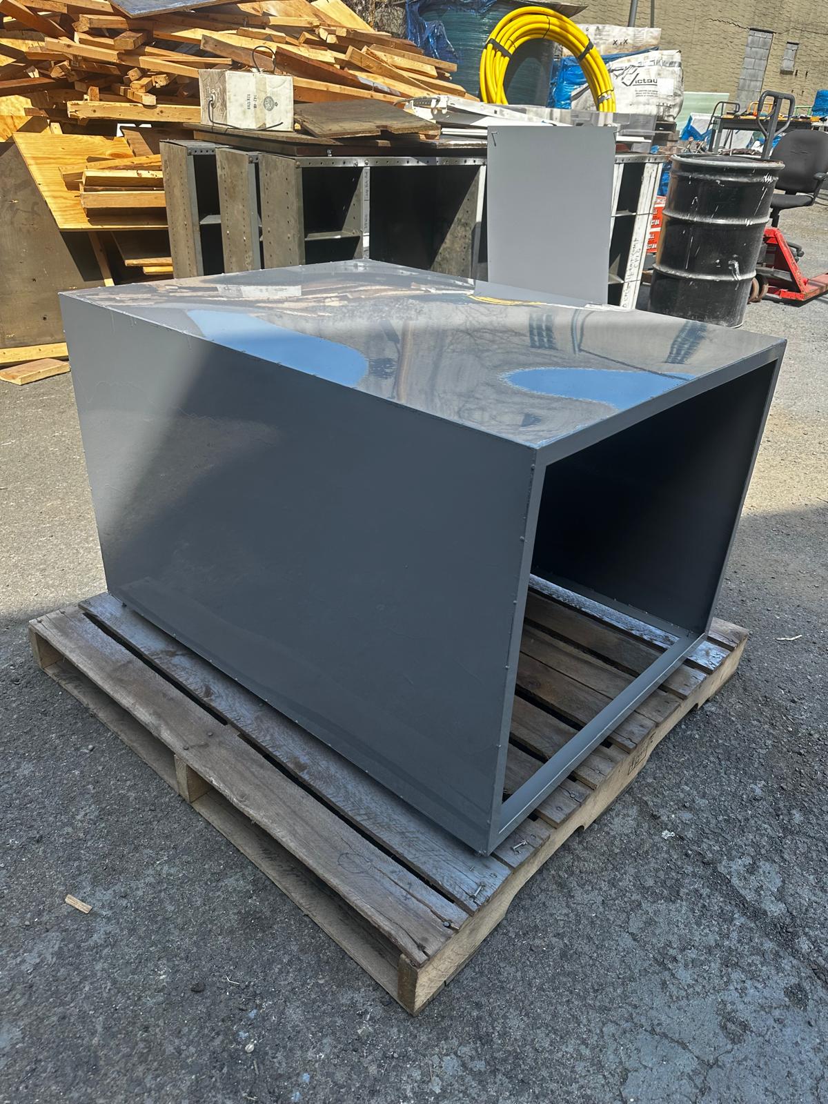 Large open-front metal enclosure on a pallet